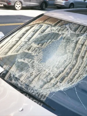 Shattered windshield with circular impact damage from a collision